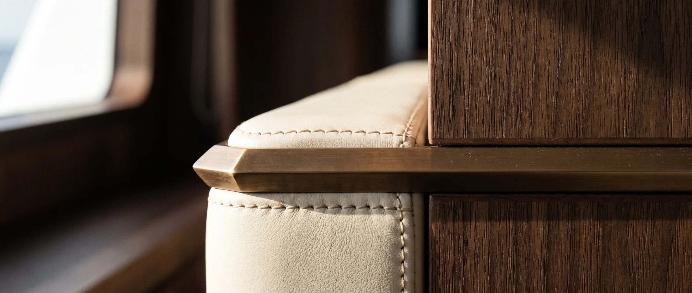 Seam. Leather against walnut. This edge is where you see the work.